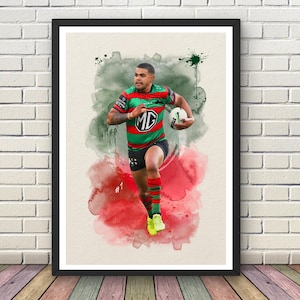 Puede incluir: Impresión enmarcada de acuarela de un jugador de rugby con una camiseta roja, verde y blanca, sosteniendo un balón de rugby. La obra presenta un fondo de acuarela con salpicaduras rojas y verdes. El jugador lleva pantalones cortos negros y zapatos amarillos. El número 1 es visible.