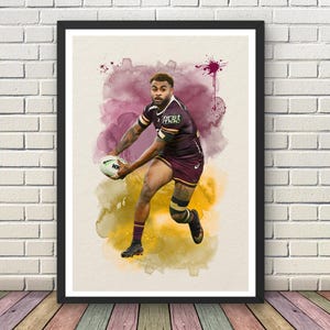 May include: A framed watercolor print of a rugby player in action, set against a backdrop of purple and yellow watercolor washes. The player is wearing a maroon and white uniform and holding a rugby ball. The print is displayed on a brick wall.