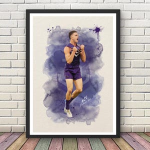 May include: Framed watercolour print of a football player in a purple uniform, celebrating a victory. The artwork features a splash of purple watercolour and the text "EST 1894". The player's number is 20, and his name is Patrick Voss.