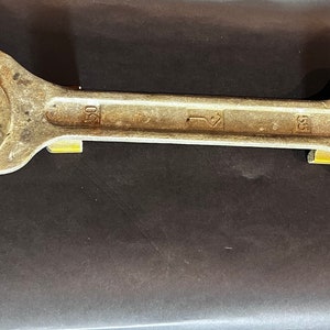 Puede incluir: Una llave inglesa plateada con una abertura de 20 mm. La llave tiene un mango negro y está hecha de metal.