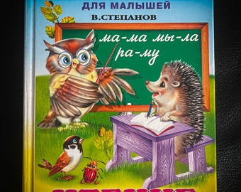 Puede incluir: Una cubierta de libro colorida con el título "УЧЕБНИК" en letras rojas. El libro es para niños pequeños y presenta ilustraciones de un búho, un erizo y un pájaro. El texto en la cubierta dice "ЧТЕНИЕ ПО СЛОГАМ".