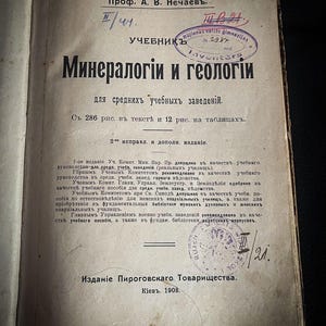 Peut inclure: Une couverture de livre vintage avec le titre "Mineralogii i Geologii" en écriture cyrillique. Le livre est un manuel pour les écoles secondaires et comprend 286 illustrations et 12 planches. Il a été publié par la Pirogovskogo Tovarischestva à Kiev en 1908.