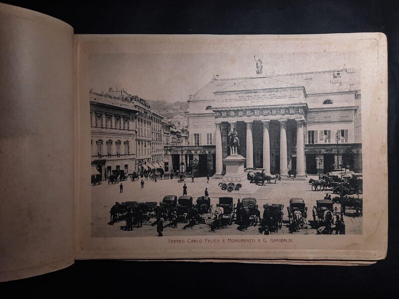 May include: A black and white photo of the Teatro Carlo Felice opera house in Genoa, Italy. The photo shows the front of the building with a statue of Giuseppe Garibaldi in front of it. The text "Teatro Carlo Felice e Monumento a G. Garibaldi" is printed below the image.