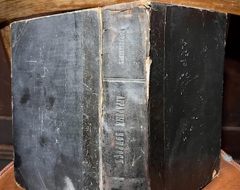 May include: A black leather-bound book with the title "GERMAN BOTANICS" embossed on the spine. The book is worn and has a gold-colored label on the front cover.