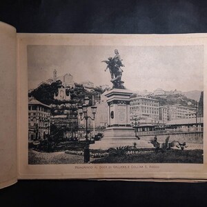 May include: A black and white photo of a monument to the Duke of Galliera and the hill of Rocca. The monument is a statue of a man on horseback, and it is located in a city setting. The photo is from an old postcard.