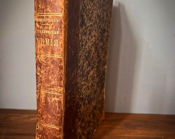 May include: A vintage, brown leather-bound book with gold lettering on the spine. The title is "Handbuch der Ukrainischen Grammatik".