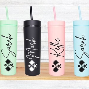 K&ouml;nnte beinhalten: Vier personalisierte hohe Becher mit Strohhalmen. Die Becher sind in Gr&uuml;n, Schwarz, Rosa und Blau. Jeder Becher hat einen Namen darauf geschrieben: Sarah, Mark, Kellie und Sarah. Jeder Becher hat ein Schwarzwei&szlig;bild von zwei Paddleball-Schl&auml;gern und einem Ball.