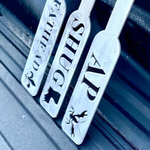 Puede incluir: Tres letreros de metal con diferentes dise&ntilde;os y textos. Los letreros est&aacute;n etiquetados como "VIP", "SUGS" y "FALKEN", con un peque&ntilde;o dise&ntilde;o en cada letrero.