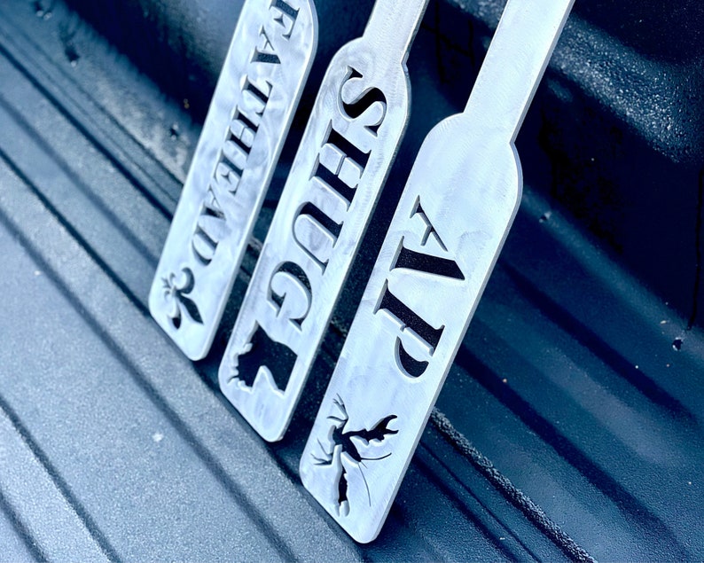 Puede incluir: Tres letreros de metal con diferentes dise&ntilde;os y textos. Los letreros est&aacute;n etiquetados como "VIP", "SUGS" y "FALKEN", con un peque&ntilde;o dise&ntilde;o en cada letrero.