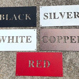 May include: Five metal signs with different colors and the words "BLACK", "SILVER", "WHITE", "COPPER", and "RED" cut out of the metal.
