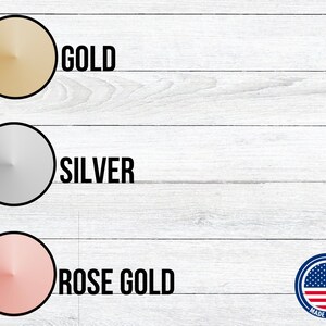 May include: Three round metal discs in gold, silver, and rose gold colors. The discs are arranged vertically on a white wood background. The text "GOLD", "SILVER", and "ROSE GOLD" is printed below each disc. A small American flag is in the lower right corner with the text "MADE IN USA".
