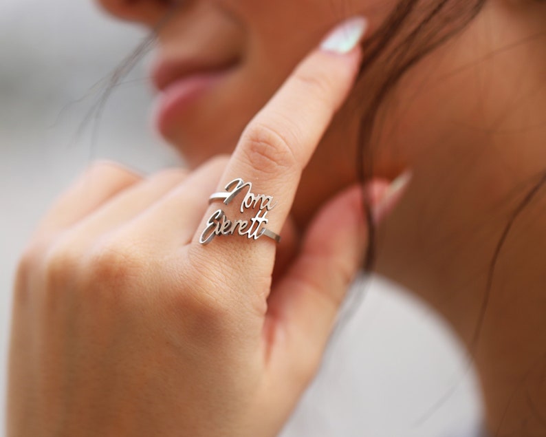 May include: A silver ring with the names "Nora Everett" written in cursive script.