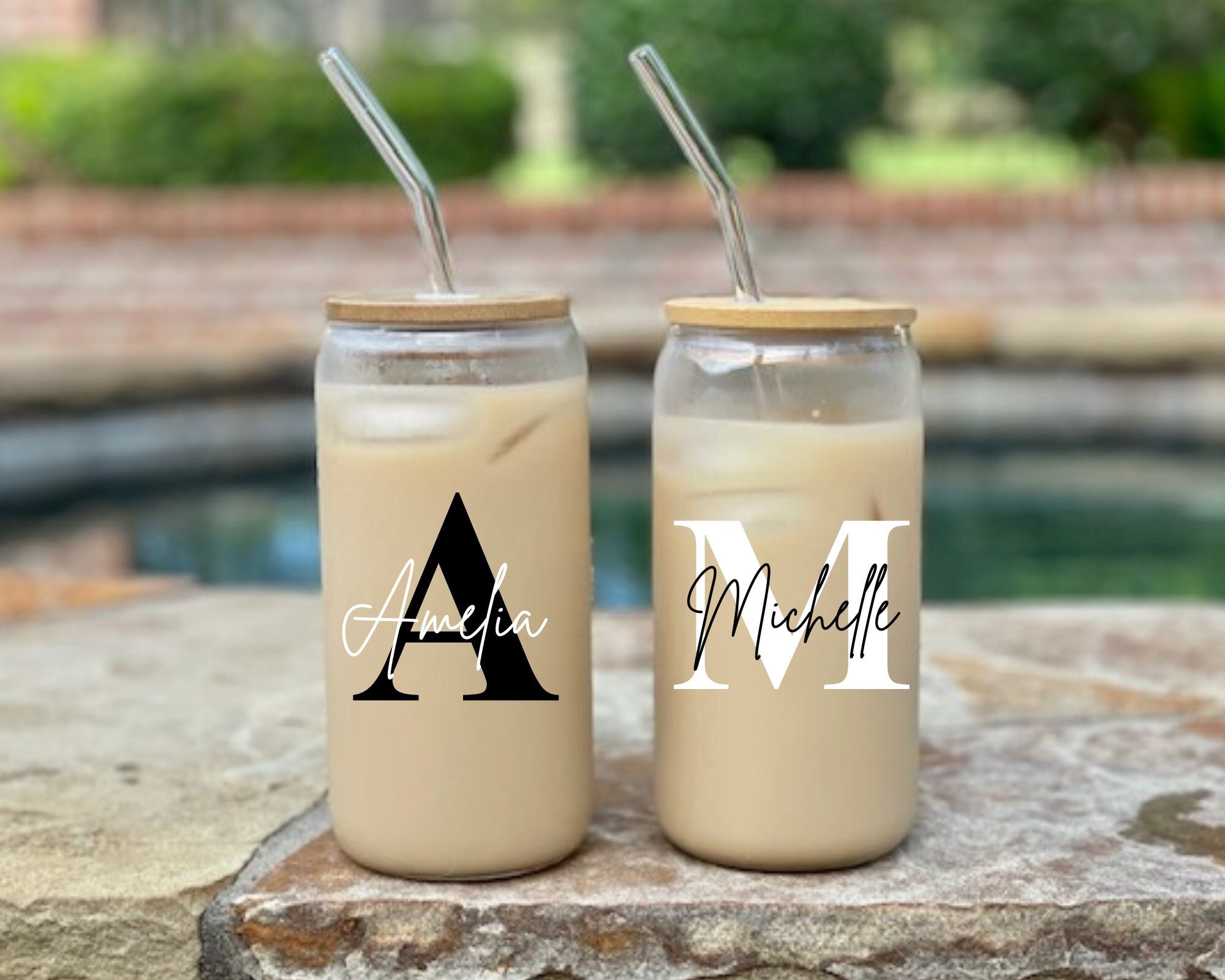 Two ice cold coffee drinks in drinking glasses near black framed