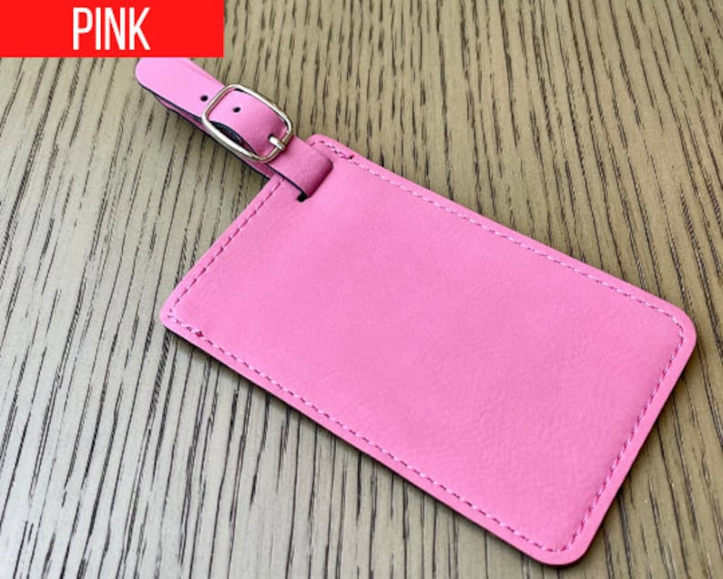 Peut inclure: Une &eacute;tiquette &agrave; bagages en cuir rose avec une boucle argent&eacute;e. L'&eacute;tiquette a un bord cousu.