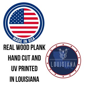 May include: A wooden sign with the text "MADE IN USA" in a blue circle with a red, white, and blue American flag inside. Below the circle, the text reads "REAL WOOD PLANK HAND CUT AND UV PRINTED IN LOUISIANA". A blue circle with a white outline of Louisiana and a white lobster inside is below the text. The circle is surrounded by red stars.
