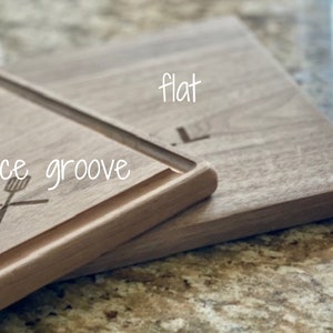 Puede incluir: Tabla de cortar de madera con ranura para jugos y la palabra "flat" grabada en la superficie. Las palabras "juice groove" est&aacute;n escritas en cursiva. Una esp&aacute;tula y un tenedor est&aacute;n grabados en la tabla.