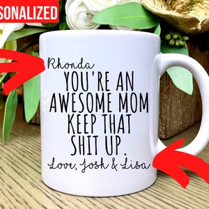 May include: White ceramic mug with black text that reads "Rhonda YOU'RE AN AWESOME MOM KEEP THAT SHIT UP. Love, Josh & Lisa." The word "PERSONALIZED" is in a red box at the top. The mug has a white handle.