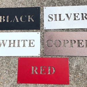 May include: Five metal signs with different colors and the words "BLACK", "SILVER", "WHITE", "COPPER", and "RED" cut out of the metal.