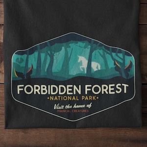 May include: Black t-shirt with a graphic of a forest scene with a unicorn. The text reads "Forbidden Forest - National Park - Visit the home of magical creatures."