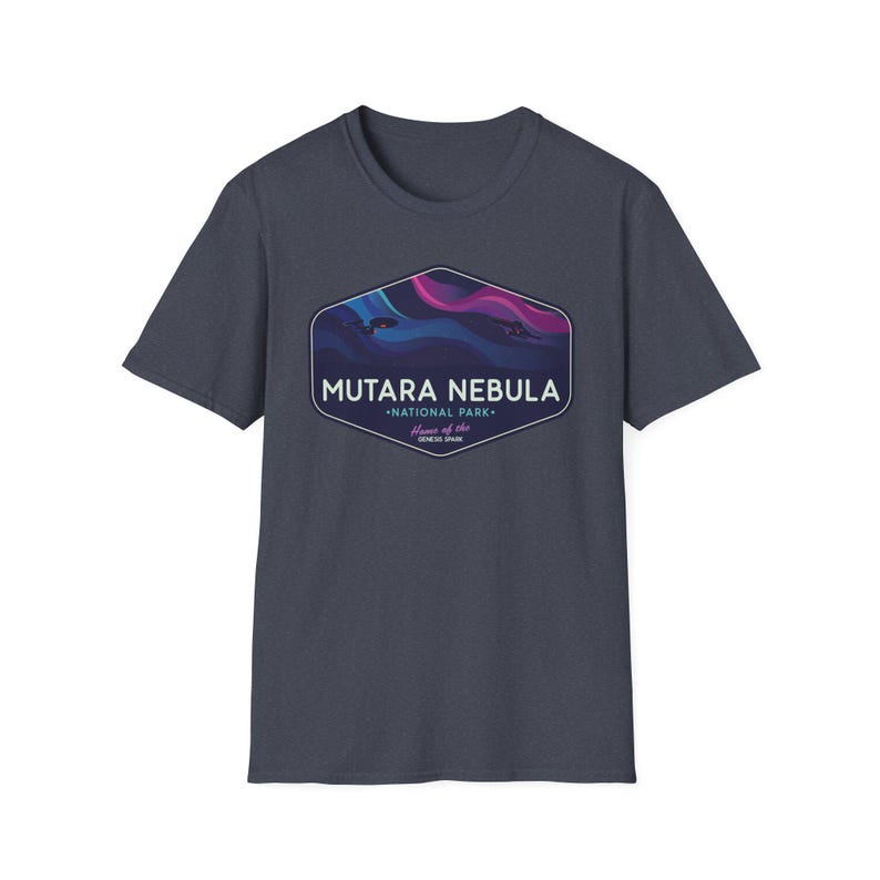 May include: Dark gray t-shirt featuring a graphic of the Mutara Nebula National Park. The graphic includes a stylized nebula design in shades of blue, purple, and pink, with the text "MUTARA NEBULA" and "NATIONAL PARK".