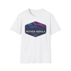 May include: White t-shirt featuring a graphic of the Mutara Nebula National Park. The design includes the text "Mutara Nebula" above "National Park" and "Home of the Gemini Span" in a dark blue, purple, and pink color scheme.