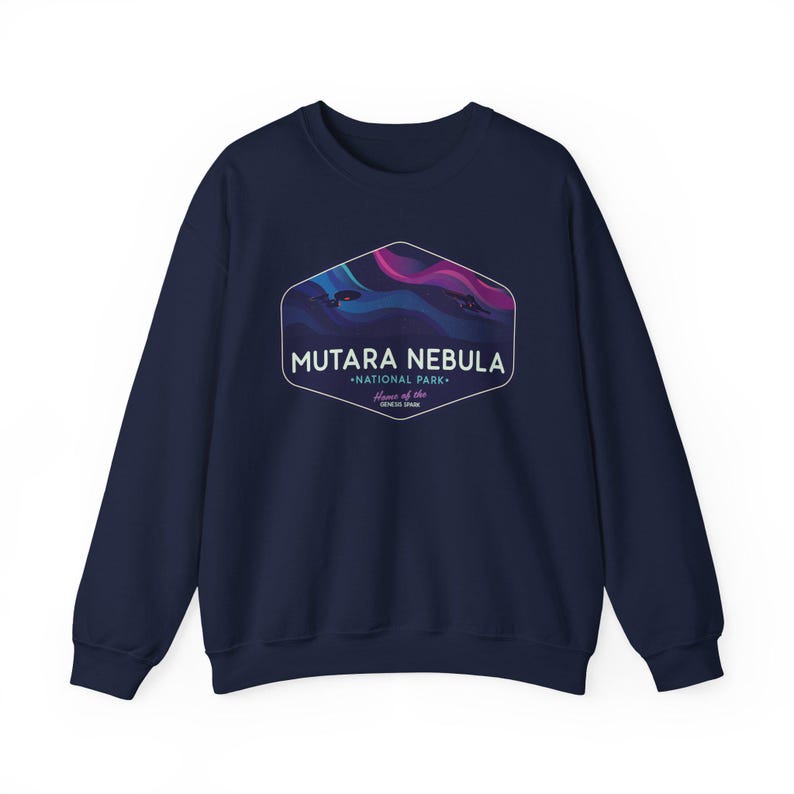 May include: A navy blue sweatshirt featuring a hexagonal graphic with the words "MUTARA NEBULA - NATIONAL PARK - Home of the GENESIS SPARK". The graphic has a wavy design in shades of blue, purple, and pink.