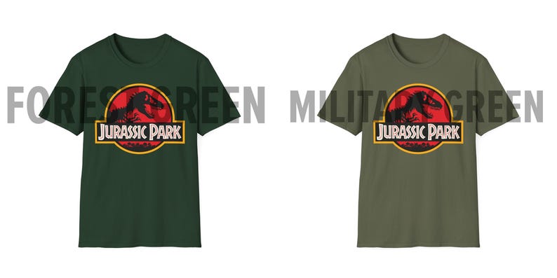 May include: Two short-sleeved t-shirts, one forest green and one military green, each featuring the "Jurassic Park" logo. The logo includes a red circle with a dinosaur silhouette, the words "JURASSIC PARK" in a yellow-bordered rectangle.
