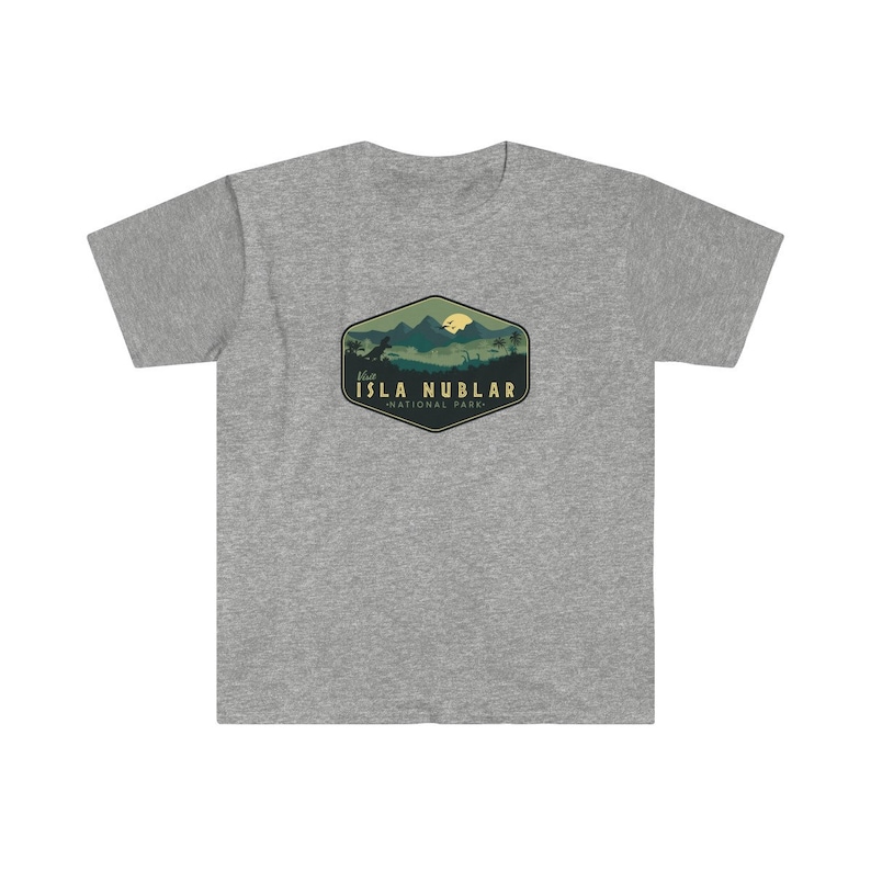 K&ouml;nnte beinhalten: Graues T-Shirt mit einer gr&uuml;nen, gelben und braunen Grafik einer Bergkette mit einem Dinosaurier und dem Text "Besuchen Sie Isla Nublar - Nationalpark."