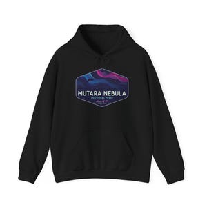 May include: Black hooded sweatshirt with a front pocket and drawstring. The front features a hexagonal design with the text "MUTARA NEBULA NATIONAL PARK" and a colorful nebula graphic in shades of blue, purple, and pink. The phrase "House of the Aurora Borealis" is below.