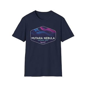May include: Navy blue t-shirt featuring a graphic of the Mutara Nebula National Park. The graphic is a stylized depiction of a nebula with shades of blue, purple, and pink. Text on the graphic reads "Mutara Nebula National Park" and "Home of the Genesis Spire."