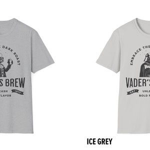 May include: Two gray t-shirts with a black and white graphic of Darth Vader holding a coffee cup. The text on the shirts reads "Embrace the Dark Roast, Vader's Brew, Est. 1977, Unleash Bold Flavor". The shirts are labeled "Sport Grey" and "Ice Grey".