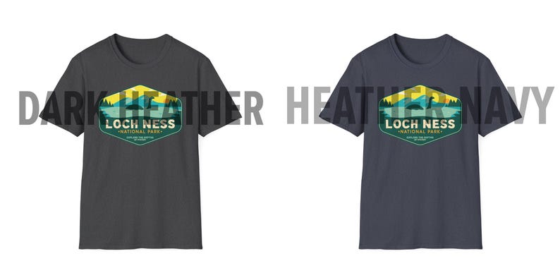 May include: Two t-shirts with a vintage-style graphic of Loch Ness National Park. The shirt on the left is dark heather grey and the shirt on the right is heather navy.