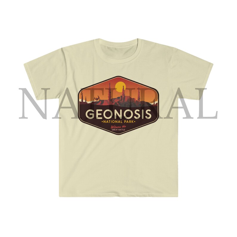 May include: A beige t-shirt featuring a vintage-style graphic of a sunset over a cityscape. The graphic reads "Geonosis National Park" and "Welcome to the Great Battle".