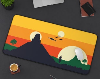 May include: A yellow, orange, and brown sunset themed mousepad with a silhouette of a mountain, a small tree, and a person standing in front of it. There are three small flying objects in the sky.