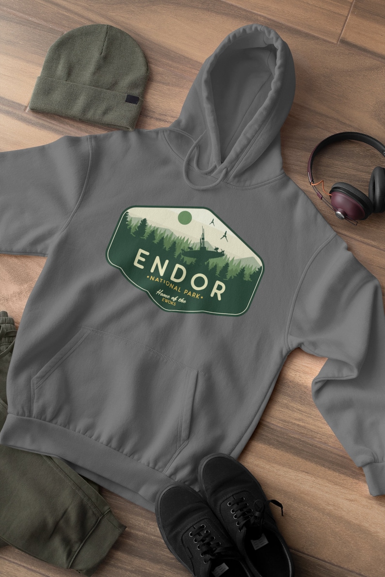 May include: Gray hooded sweatshirt with a green and white graphic of a forest scene with a spaceship and the text "Endor National Park. Home of the Ewoks."