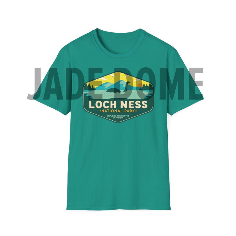 May include: Teal blue t-shirt with a vintage-style graphic of a Loch Ness Monster in a lake with the text "Loch Ness National Park. Explore the Depths of Legend."