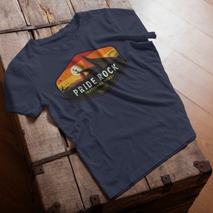 May include: A navy blue t-shirt with a vintage-style graphic of a mountain range and the text "PRIDE ROCK NATIONAL PARK, TELLURIDE".