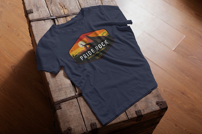 May include: A navy blue t-shirt with a vintage-style graphic of a mountain range and the text "PRIDE ROCK NATIONAL PARK, TELLURIDE".