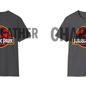 May include: Two dark gray t-shirts with the Jurassic Park logo. The logo features a red circle with a dinosaur silhouette, a yellow border, and the words "JURASSIC PARK" in white. The shirts are displayed on a white background.