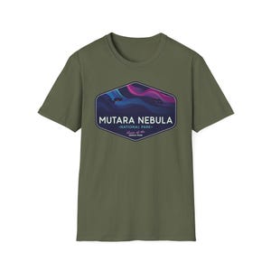 May include: Olive green t-shirt featuring a hexagonal graphic with the text "MUTARA NEBULA - NATIONAL PARK - Home of the GENESIS SPAN." The graphic depicts a colorful nebula scene in shades of blue, purple, and pink.