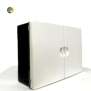 Op de afbeelding: Een witte vintage kast met twee deuren en een afgeronde handgreep. De kast heeft een zwarte zijkant en staat tegen een witte achtergrond. Het logo "20 90 vintage" staat in de linkerbovenhoek.
