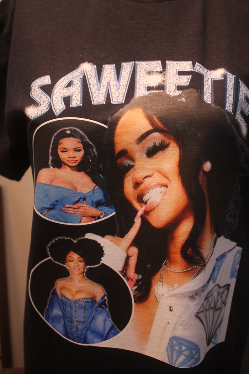 May include: Black t-shirt with a rhinestone design that says "Sweetie" and features three images of women in blue clothing.