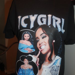 May include: Black t-shirt with a graphic print of a woman with a diamond necklace and the text "ICYGIRL" in rhinestones.