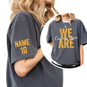 May include: Two charcoal gray t-shirts with yellow text. One shirt says "We Are Custom Team" and the other says "NAME 10" on the sleeve.