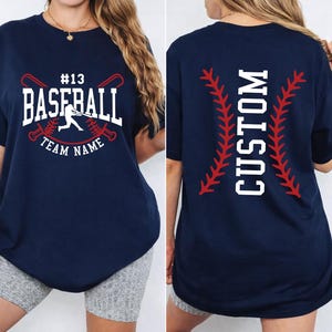 A woman wearing a navy blue t-shirt with a baseball design and the text "CUSTOM" printed on the back.