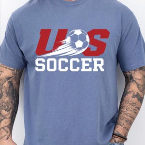A man wearing a blue t-shirt with the text "US SOCCER" printed on it.