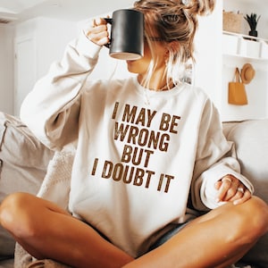 May include: A white sweatshirt with the text "I may be wrong but I doubt it" printed in brown on the front.