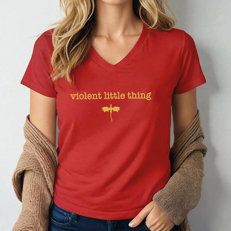 A woman wearing a red t-shirt with the text "violent little thing" printed on it.