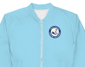 May include: Light blue bomber jacket with a white interior and a full-length zipper. The jacket features a circular emblem on the chest with the text "TEAM ZISSOU MASTER FROGMAN" and a stylized "Z" in the center. The jacket is a solid light blue color.