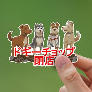 May include: A sticker featuring four cartoon dogs of different breeds. The dogs are brown, gray, and tan, with one wearing a striped shirt. Japanese text in red is below the dogs.